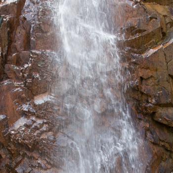 Closeup of a waterfall against a granite background