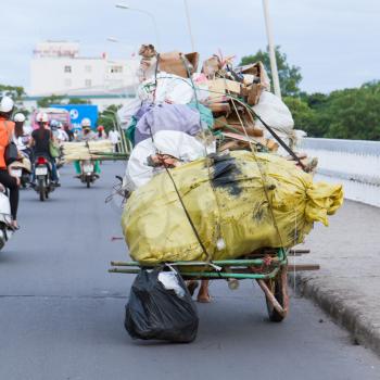 Traffic in Hue, woman is transporting cartboard and plastic