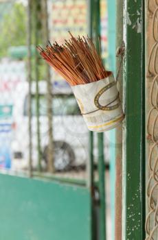 Incence sticks in an cut beer can on a wall, Vietnam