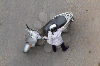 Top view of a woman holding a grey scooter, Vietnam