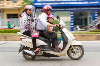 DONG HOI, VIETNAM, 7 AUGUST 2012 - Complete Vietnamese family with a bicycle on a scooter. With an estimated number of 20 million the scooter is Vietnams most important means of transportation. DONG H