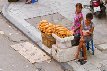 HANOI, VIETNAM, 8 AUGUST 2012; Vietnamese street vendor selling France loaf at street. Estimate 10.6% of Vietnam's population is below the poverty line. HANOI, VIETNAM, 8 AUGUST 2012