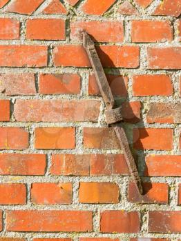 Old rusty clamp in a brick wall, isolated
