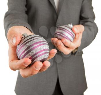Man in grey suit is holding Christmass balls, isolated