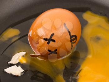 Cracked egg (dead) in a pan, isolated