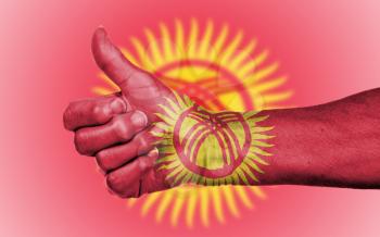 Old woman giving the thumbs up sign, isolated, flag of Kyrgyzstan