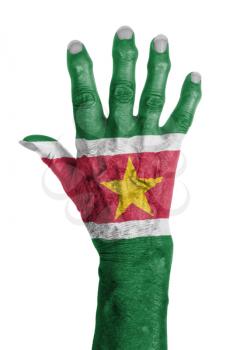 Hand of an old woman wrapped in flag of Suriname