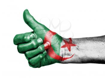 Old woman with arthritis giving the thumbs up sign, wrapped in flag pattern, Algeria