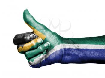 Old woman with arthritis giving the thumbs up sign, wrapped in flag pattern, South Africa
