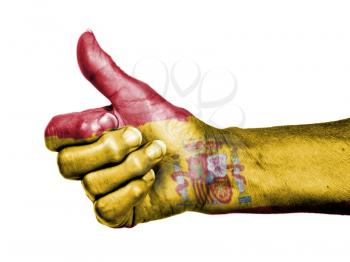 Old woman with arthritis giving the thumbs up sign, wrapped in flag pattern, Spain