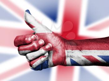 Union Jack on thumbs up hand isolated on a flag background