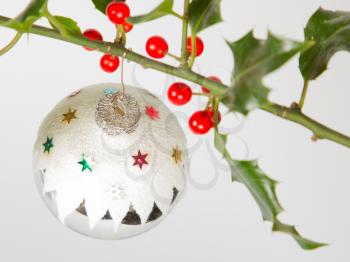 Very old silver christmas ball hanging from a twig (butchers broom), isolated