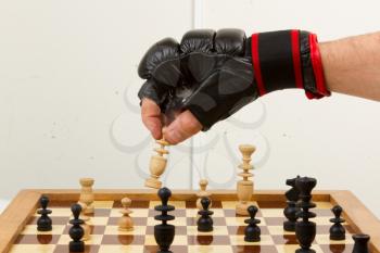 Playing chess in freefight gloves, isolated on white