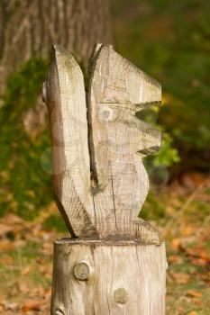 Carving of a wooden squirrel on a forest background