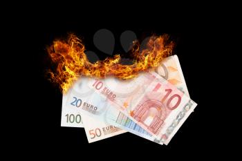 Burning money, euro bills on fire, isolated on black