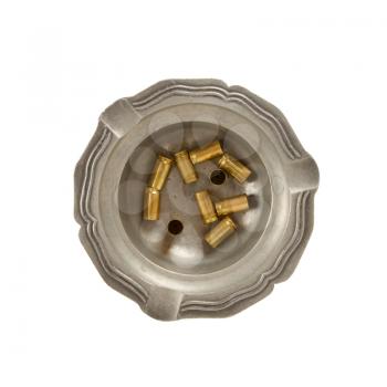 Burning cigarette and empty 9mm bullet casings in an old tin ashtray, isolated