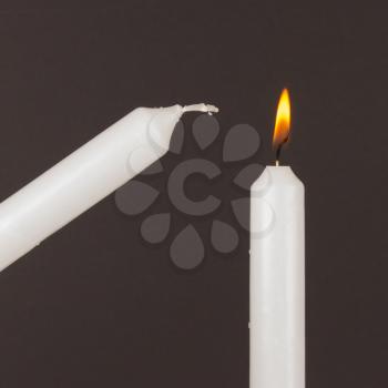 Burning white candle, isolated on black background