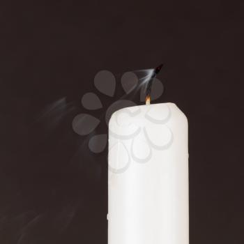 White candle isolated against a black background