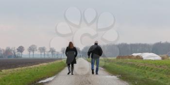 Man and woman walking on a road