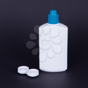 Lens casing and bottle of water isolated on black, contact lenses