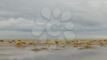 Low tide at the dunes of Ameland, dark sky, Holland