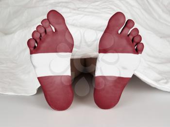 Feet with flag, sleeping or death concept, flag of Latvia