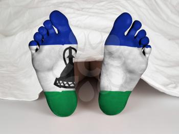 Feet with flag, sleeping or death concept, flag of Lesotho
