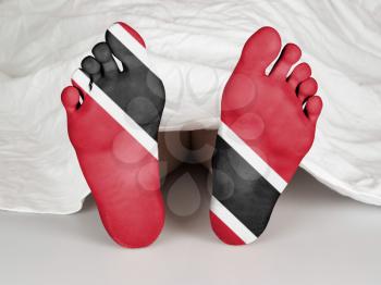 Feet with flag, sleeping or death concept, flag of Trinidad and Tobago