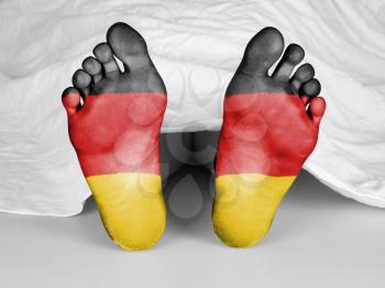 Dead body under a white sheet, flag of Germany