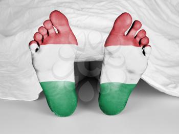 Dead body under a white sheet, flag of Hungary