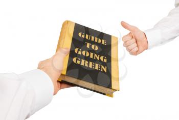 Businessman giving an used book to another businessman, guide to going green