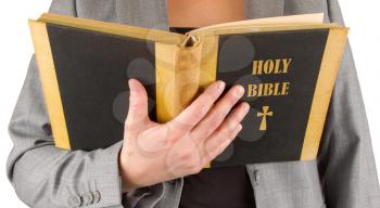 Woman in business suit is reading a holy bible, close-up