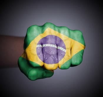 Front view of punching fist on gray background, flag of Brazil