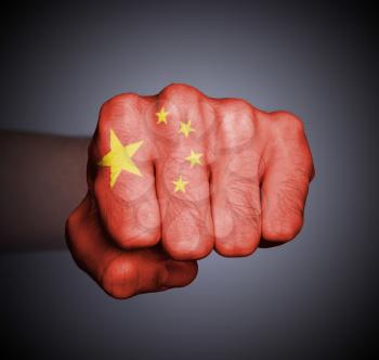 Front view of punching fist on gray background, flag of China
