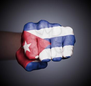 Front view of punching fist on gray background, flag of Cuba