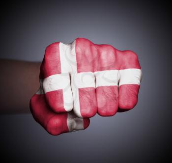 Front view of punching fist on gray background, flag of Denmark