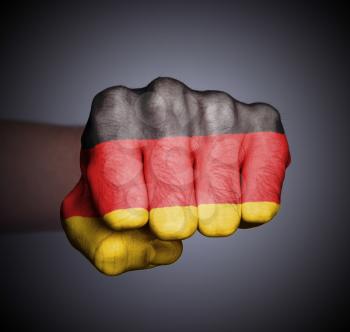Front view of punching fist on gray background, flag of Germany