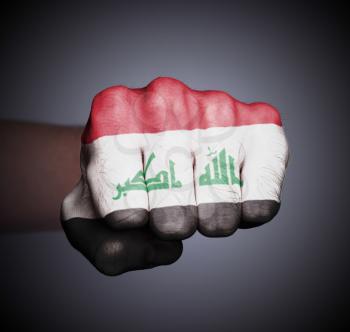 Front view of punching fist on gray background, flag of Iraq