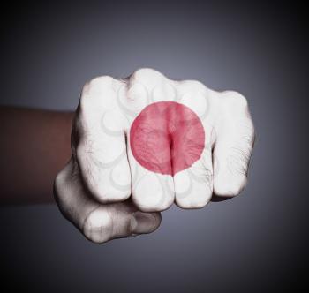 Front view of punching fist on gray background, flag of Japan