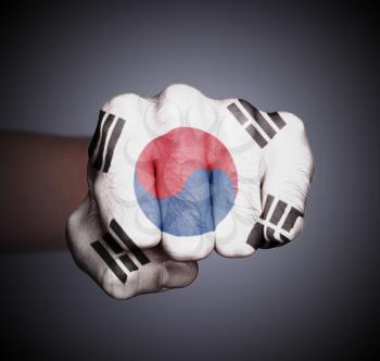 Front view of punching fist on gray background, flag of South Korea