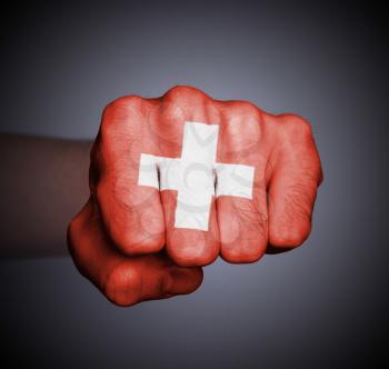 Front view of punching fist on gray background, flag of Switzerland