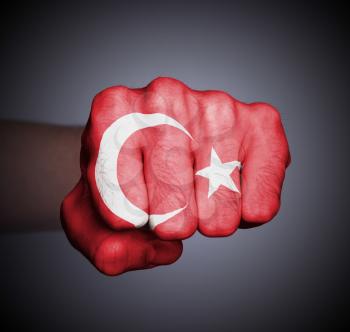 Front view of punching fist on gray background, flag of Turkey