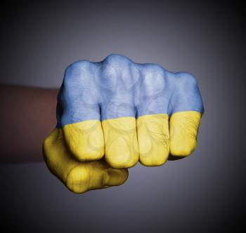 Front view of punching fist on gray background, flag of Ukraine