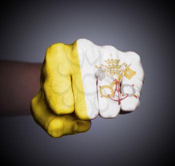 Front view of punching fist on gray background, flag of the Vatican