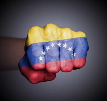 Front view of punching fist on gray background, flag of Venezuela