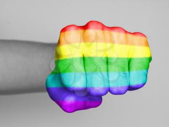 Very hairy knuckles from the fist of a man punching, rainbow flag pattern
