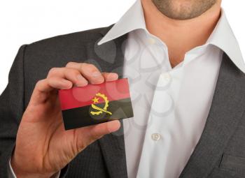 Businessman is holding a business card, flag of Angola