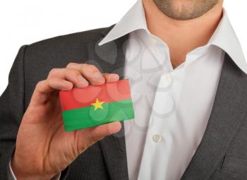 Businessman is holding a business card, flag of Burkina Faso