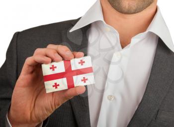 Businessman is holding a business card, flag of Georgia