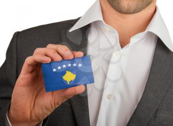 Businessman is holding a business card, flag of Kosovo